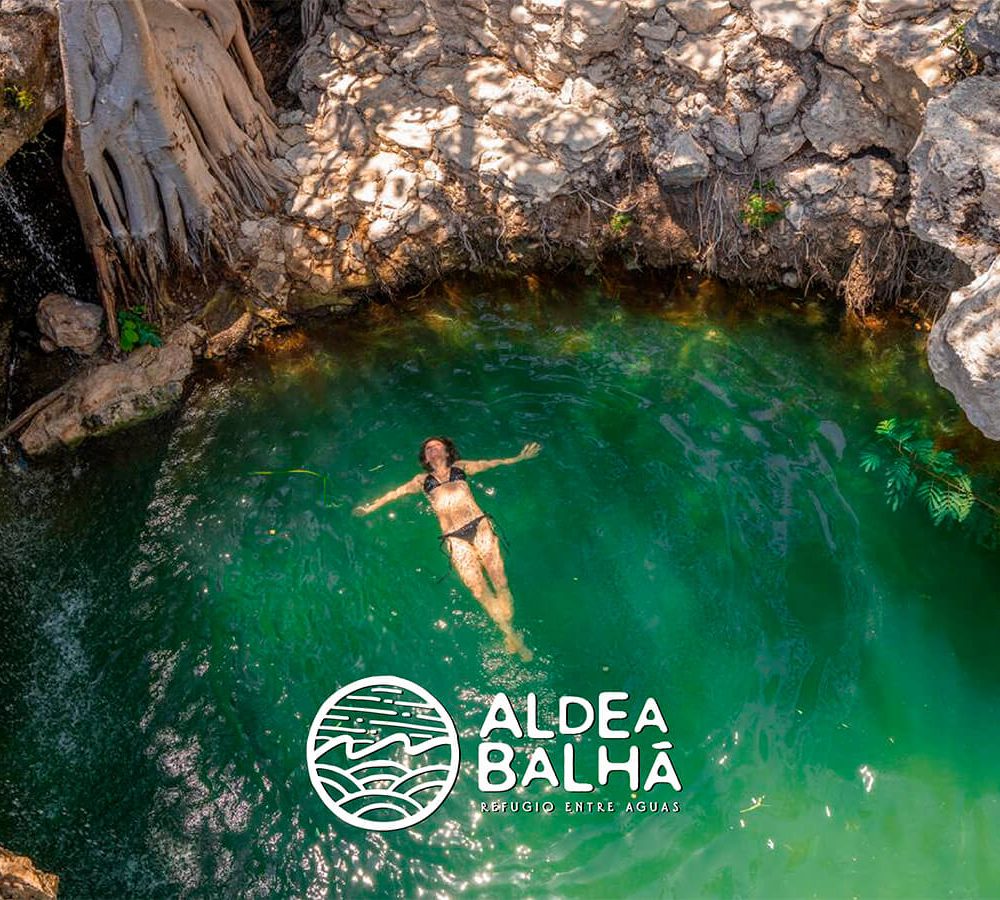 Chica nadando en el cenote de Aldea Balha terrenos residenciales cerca de la playa en Telchac Puerto Yucatán